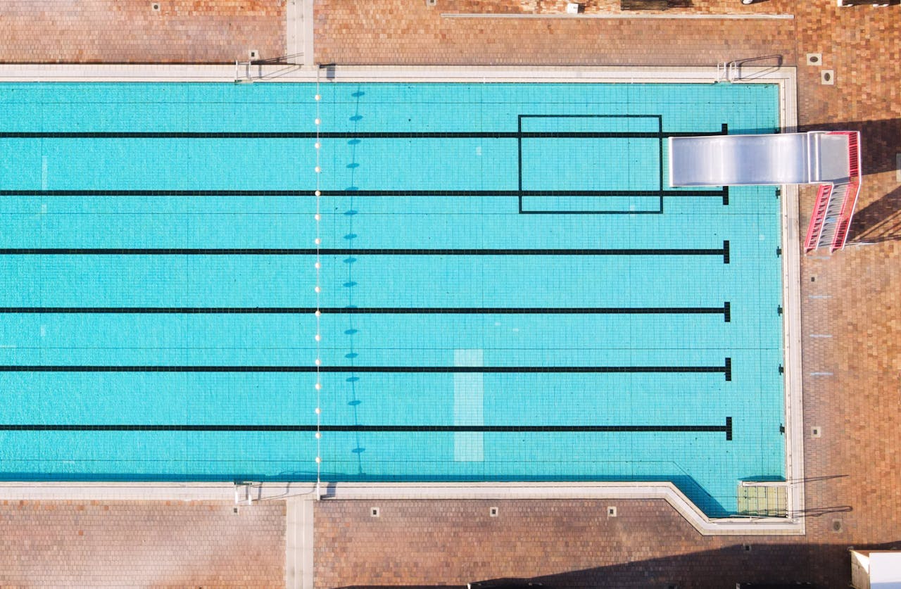 Top view of a pristine swimming pool with clear water and diving board in Oberviechtach.